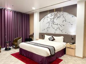 1 dormitorio con 1 cama grande y cortinas moradas en B.O.B Hotel, en Cao Lãnh