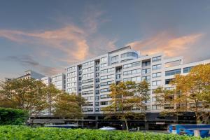 a large white building with trees in front of it at Rydges Sydney Central in Sydney