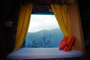 ventana con vistas a la montaña en Dirghayu Bhava Retreat, en Dehradun