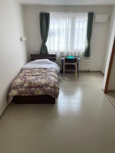 Een bed of bedden in een kamer bij ゲストハウス ikoi