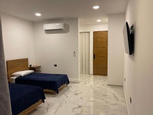 a bedroom with two beds and a tv and a hallway at Alce33 in Cancún