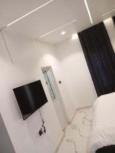 a bedroom with a tv on the wall next to a bed at 3 Bedroom Luxury Duplex (terrace) in Enugu
