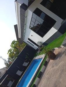 a blue and white house with a swimming pool at 3 Bedroom Luxury Duplex (terrace) in Enugu