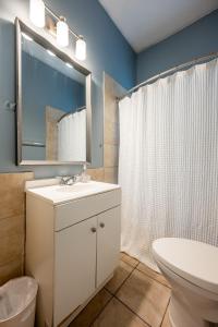 a bathroom with a sink and a toilet and a mirror at Affordable, Quaint Retreat! 5 Mins to Downtown in Indianapolis +59 photos