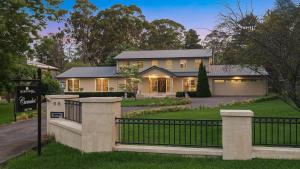 a house with a fence in front of it at Camelot in Bowral