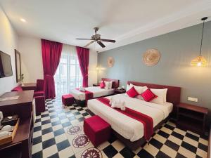 a hotel room with two beds with red accents at Mekong Angkor Palace Hotel in Siem Reap