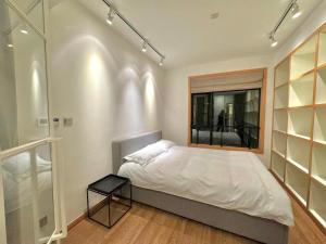 um quarto com uma cama grande e uma janela em ZHome - HaiQi Garden - Four Bedroom Apartment on the Bund with Bund View em Xangai