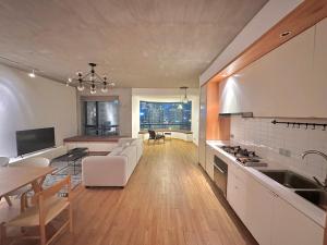 a kitchen and living room with a couch and a table at ZHome - HaiQi Garden - Four Bedroom Apartment on the Bund with Bund View in Shanghai