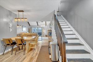 a dining room and kitchen with a staircase and a table and chairs at C52-CAMELBACK waterPark,Pool,Tennis,Zipline,hottub in Tannersville