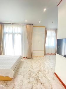 a bedroom with a bed with marble floors and windows at Mia homestay - Vinhomes Ocean Park 2 - 3 in Hòa Bình