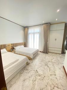 um quarto com 2 camas e piso em mármore em Mia homestay - Vinhomes Ocean Park 2 - 3 em Hòa Bình