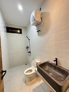 ein Bad mit einem Waschbecken und einem WC in der Unterkunft Brand New Two-Bedroom Villa with rice field views. in Tanah Lot