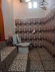ein Bad mit einem WC und einer Dusche in der Unterkunft Whynot Bar and Bungalows #01 in Pawenang