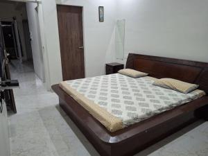 a bedroom with a large bed with a wooden headboard at 636 Kedia Kothhi in Jaipur