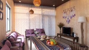 a living room with a table with a bowl of fruit on it at La Fleur Glamping in Minrong Sekang