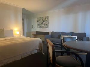 デンハムにあるヘリテージ リゾート シャーク ベイのベッド、ソファ、テーブルが備わるホテルルームです。