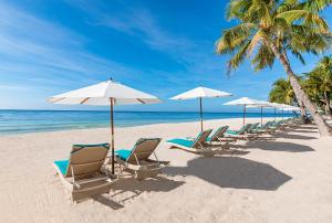 una fila de sillas y sombrillas en una playa en Henann Premier Coast Resort, en Panglao