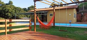 un hamac sur une terrasse à côté d'une maison dans l'établissement Chácara Santa Luzia, à Socorro