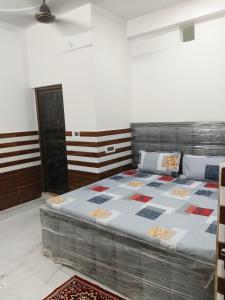um quarto com uma cama com uma colcha em Shanti Kunj Yatri Niwas em Ayodhya