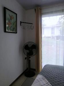 a bedroom with a fan next to a window at Villa Buenaventura in San Ramón