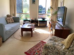 a living room with a couch and a tv at Maggie's Nest-Come & Rest in Killarney Vale