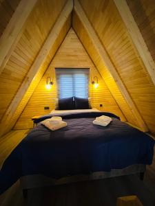 ein Schlafzimmer mit einem Bett im hölzernen Dachgeschoss in der Unterkunft Sapanca yeşilvadi 2+1 sıcak havuz,jakuzi,göl manzr in Sakarya