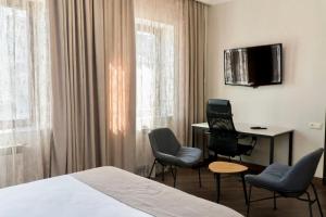 um quarto de hotel com uma cama e cadeiras e uma secretária em Hotel - Yerevan Retreat & Inn em Yerevan