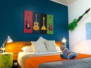 a bedroom with a bed with guitars on the wall at Acacia Motel in Chinchilla