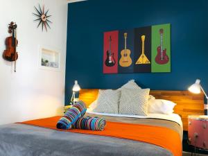 una camera da letto con un letto con chitarre appese al muro di Acacia Motel a Chinchilla