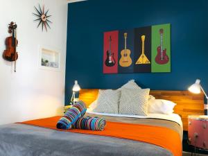 a bedroom with a bed with guitars on the wall at Acacia Motel in Chinchilla