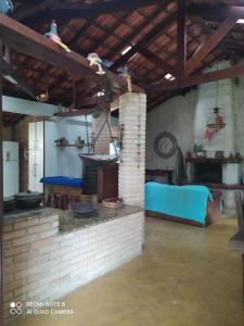 cocina con chimenea de ladrillo en una habitación en Guest House sítio do Sol Penedo, en Penedo