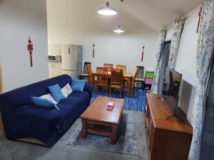a living room with a blue couch and a table at An inner city 4-bedroom house with two carparks in Wellington