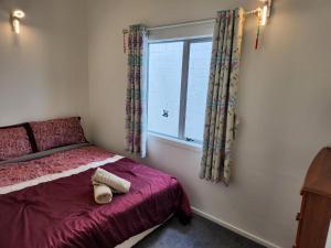 a bedroom with a bed and a window at An inner city 4-bedroom house with two carparks in Wellington