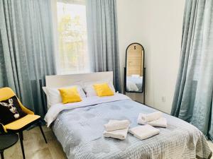 a bedroom with a bed with yellow pillows and a mirror at Abay Hostel in Almaty