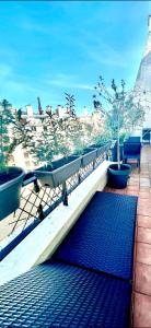 a blue mat on a balcony with potted trees at Appartement Grande Terrasse Vue Tour Eiffel in Paris