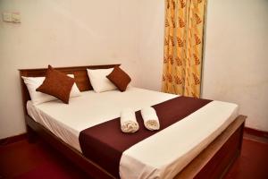 een slaapkamer met een bed met twee handdoeken erop bij Rusara Villa in Tissamaharama