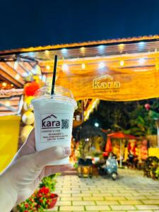 a person holding a drink in a plastic cup at Kara Homestay & Cafe in Can Tho