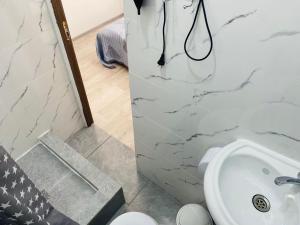 a bathroom with a white toilet and a sink at Abay Hostel in Almaty