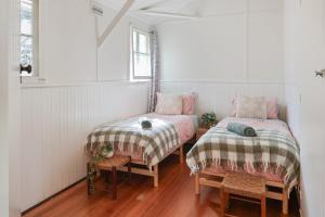 um quarto com duas camas e uma mesa e cadeiras em Pink Cabin By Host on the Coast em Barwon Heads