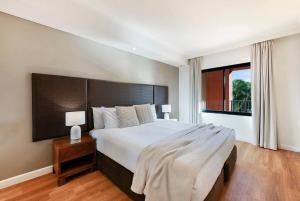 Rúm í herbergi á 'Harbour Highlight' Poolside Living on Esplanade