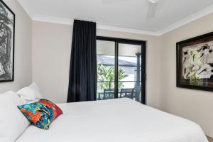 a bedroom with a white bed and a window at Byron Bay Accom Unit 3 5-9 Somerset Street - Summer Central in Byron Bay