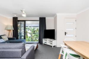a living room with a couch and a tv at Byron Bay Accom Unit 3 5-9 Somerset Street - Summer Central in Byron Bay