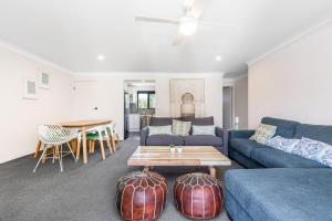 sala de estar con sofá azul y mesa en Byron Bay Accom Unit 3 5-9 Somerset Street - Summer Central, en Byron Bay