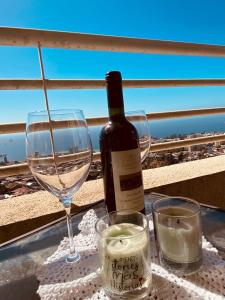 een fles wijn en twee glazen op een tafel bij Hermoso Departamento En Valparaíso, Vista Al Mar. in Valparaíso
