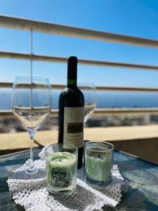 een fles wijn en twee kaarsen en een glas bij Hermoso Departamento En Valparaíso, Vista Al Mar. in Valparaíso