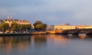 a bridge over a river in a city with buildings at La Chambre d'Hote de Mano - Centre-ville de Bayonne in Bayonne