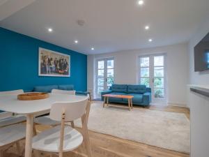 - un salon avec des murs bleus, une table et des chaises dans l'établissement Pass the Keys Stylish West End Detached Mews, à Glasgow