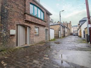 un callejón vacío con un edificio de ladrillo y una calle en Pass the Keys Stylish West End Detached Mews en Glasgow