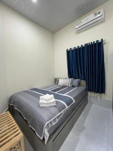 a bedroom with a bed with a blue curtain at House Mũi Né Phan Thiết KentTown in Ấp Thiện Sơn