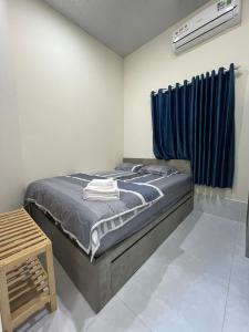 a bedroom with a bed with a blue curtain at House Mũi Né Phan Thiết KentTown in Ấp Thiện Sơn